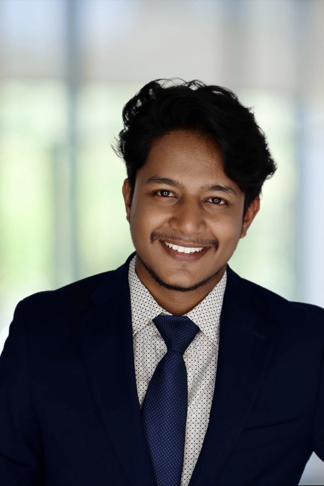 Narayan Shanku smiling while working on a laptop.